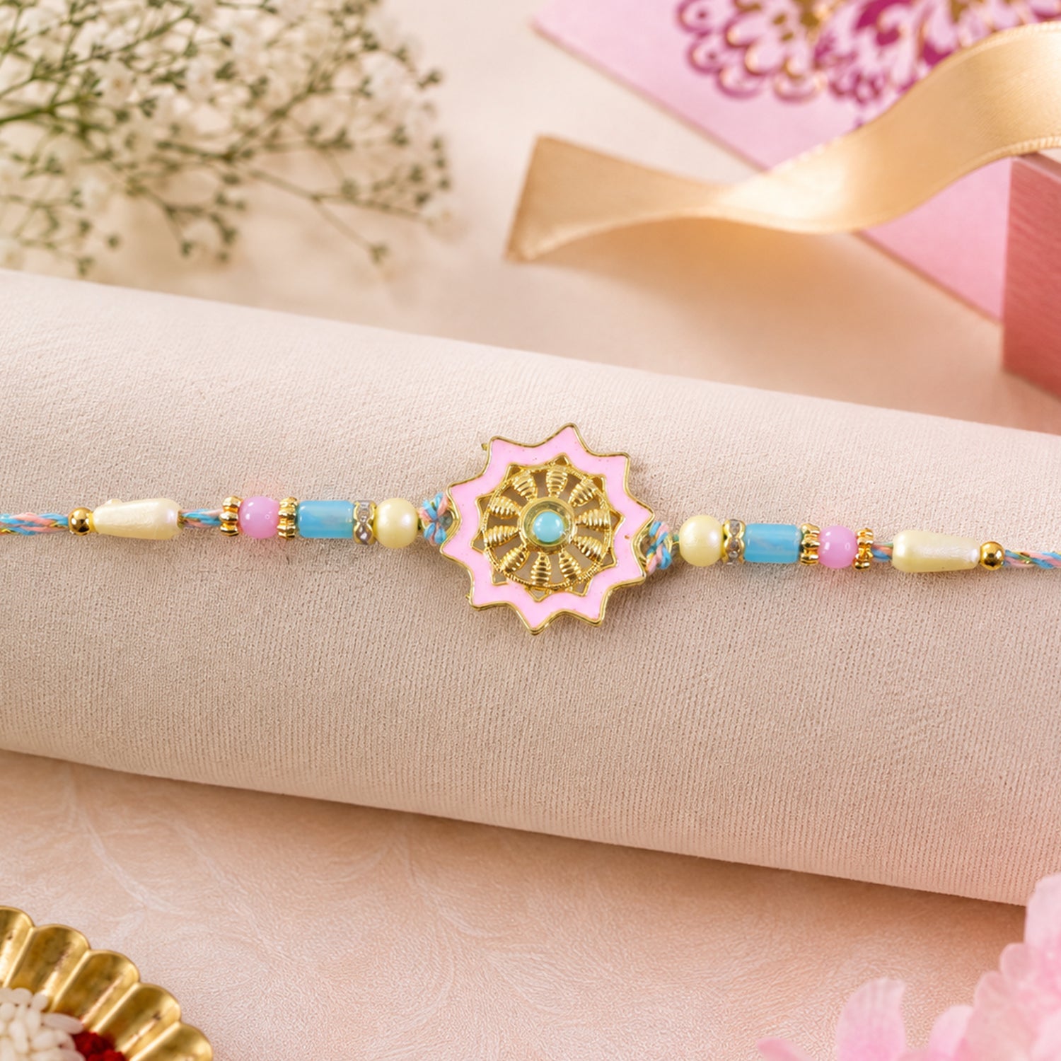 Pastel Floral Charm Rakhi with Pink Blue Beads and Elegant Festive Gift Styling Ideas