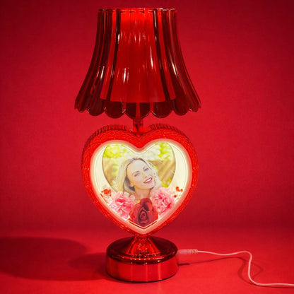 Romantic bedside lamp with glowing heart photo in bedroom