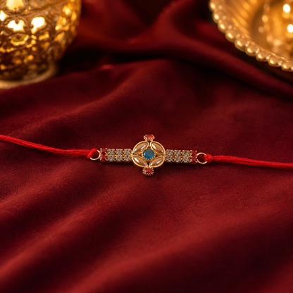 Tiny Oval Stone Rakhi with Red Thread and Delicate Gold Beads