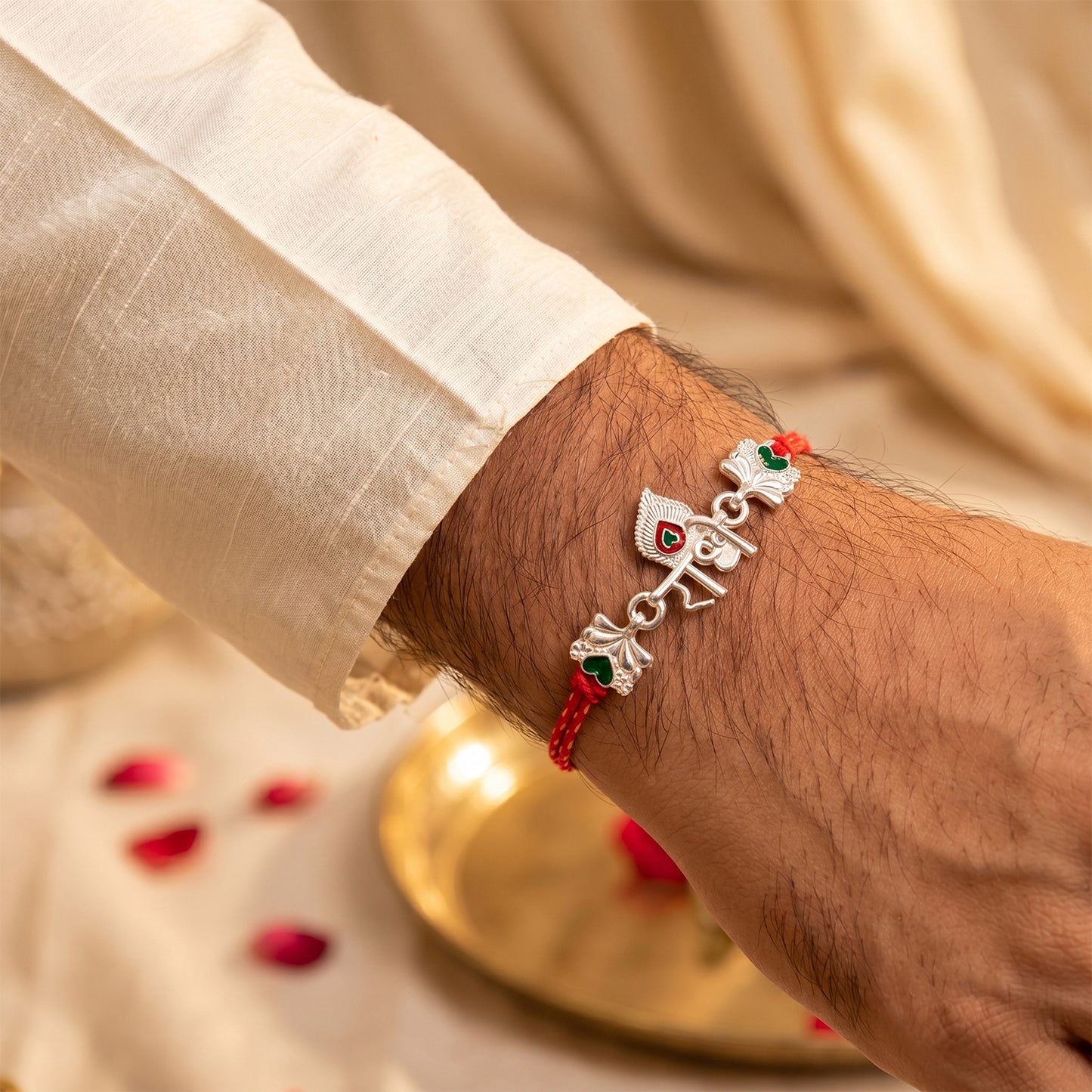 Silver Radhe Morpich Text Rakhi with Green Stones and Red Thread