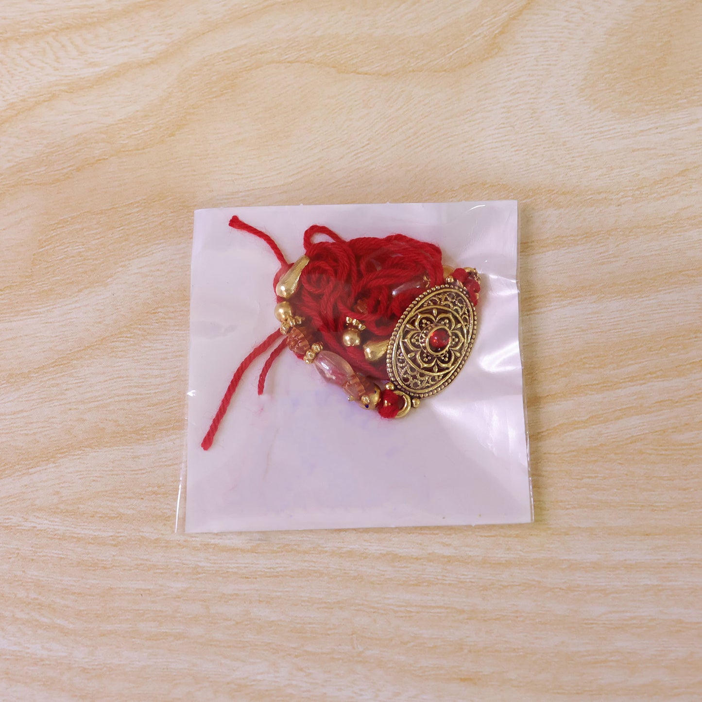 Oxidized Gold Oval Pendant Rakhi with Red Stone and Rudraksha Beads