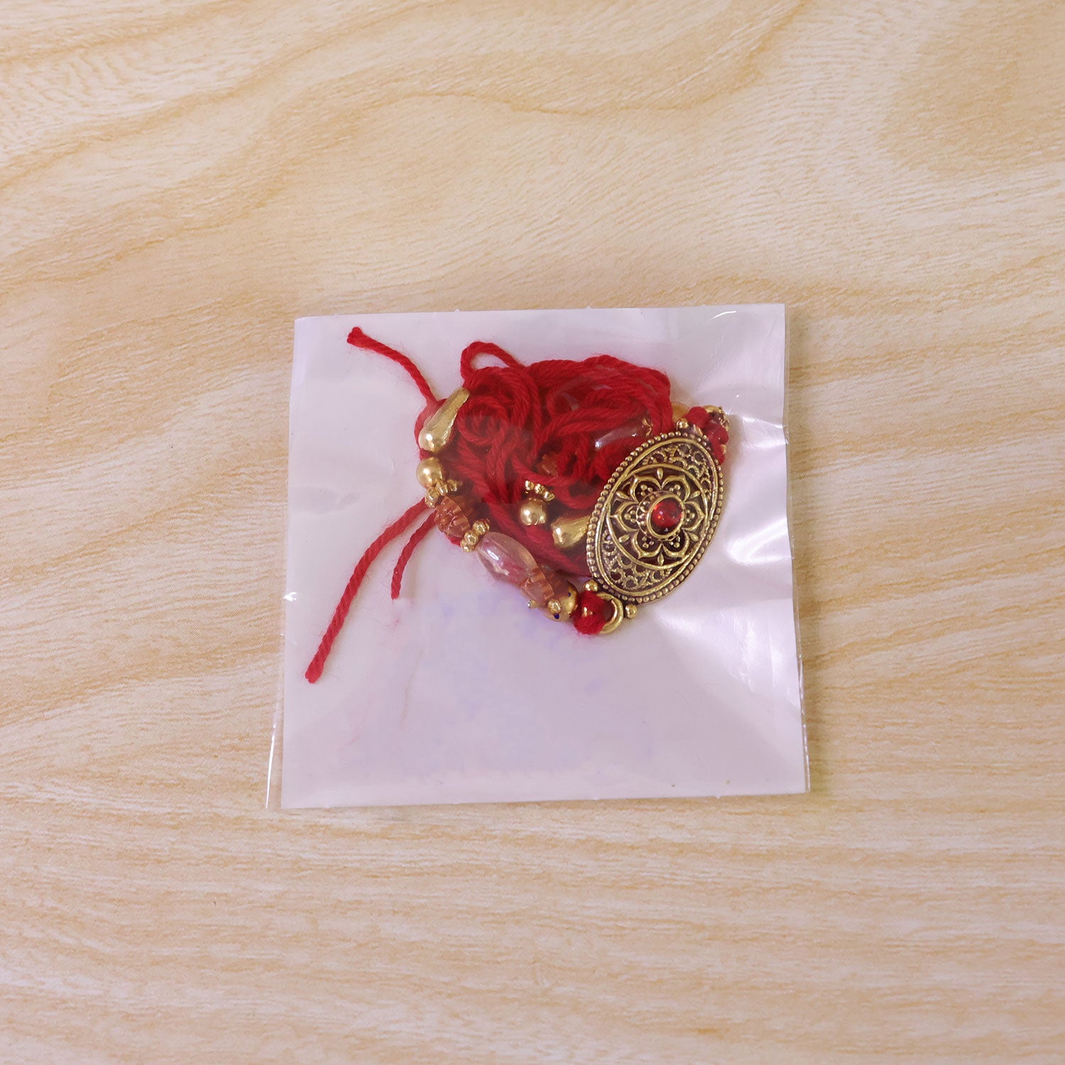 Oxidized Gold Oval Pendant Rakhi with Red Stone and Rudraksha Beads