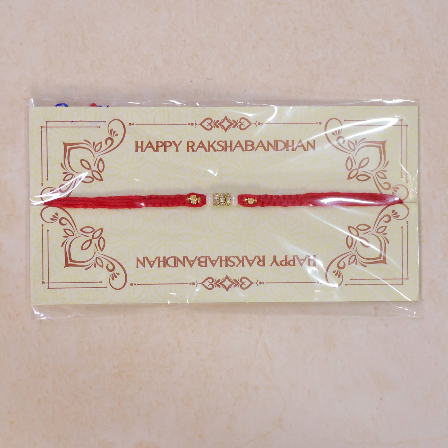Red Braided Rakhi with White Beads and Antique Gold Accent Charms
