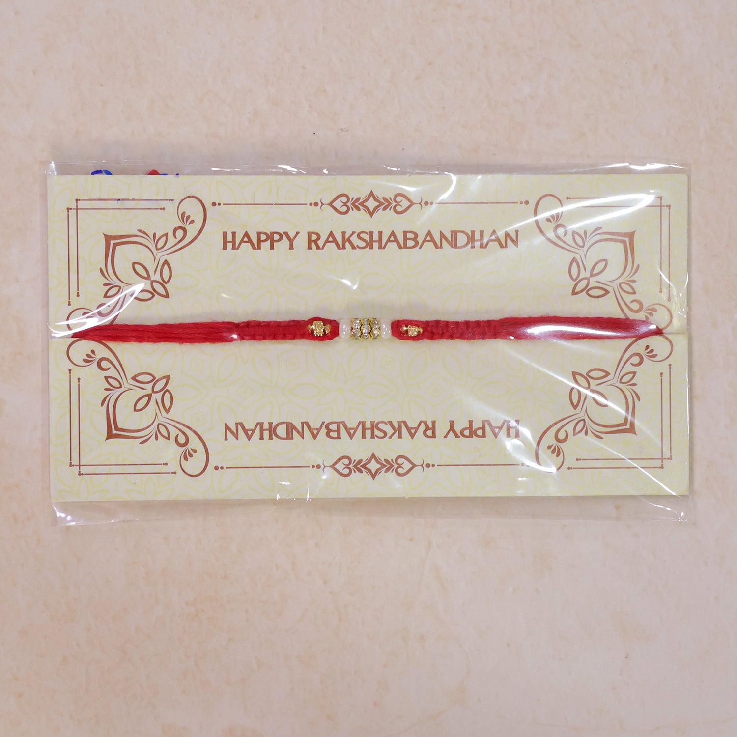 Red Braided Rakhi with White Beads and Antique Gold Accent Charms