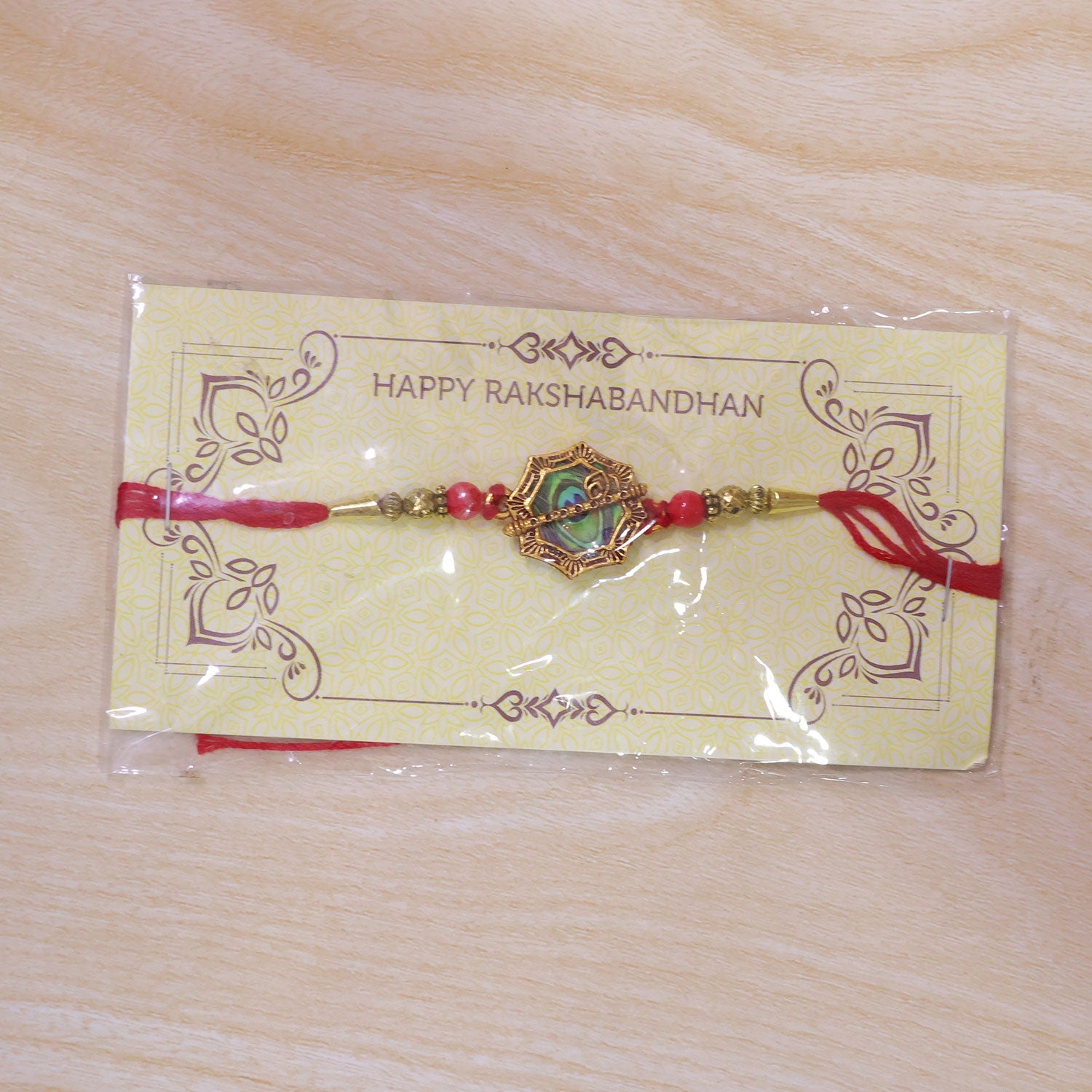 Shop Peacock Feather Rakhi Golden Frame Red Beads (10pcs)