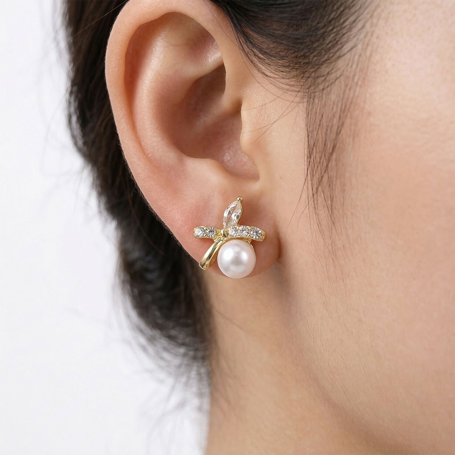 Detailed view of pearl butterfly earrings' intricate design