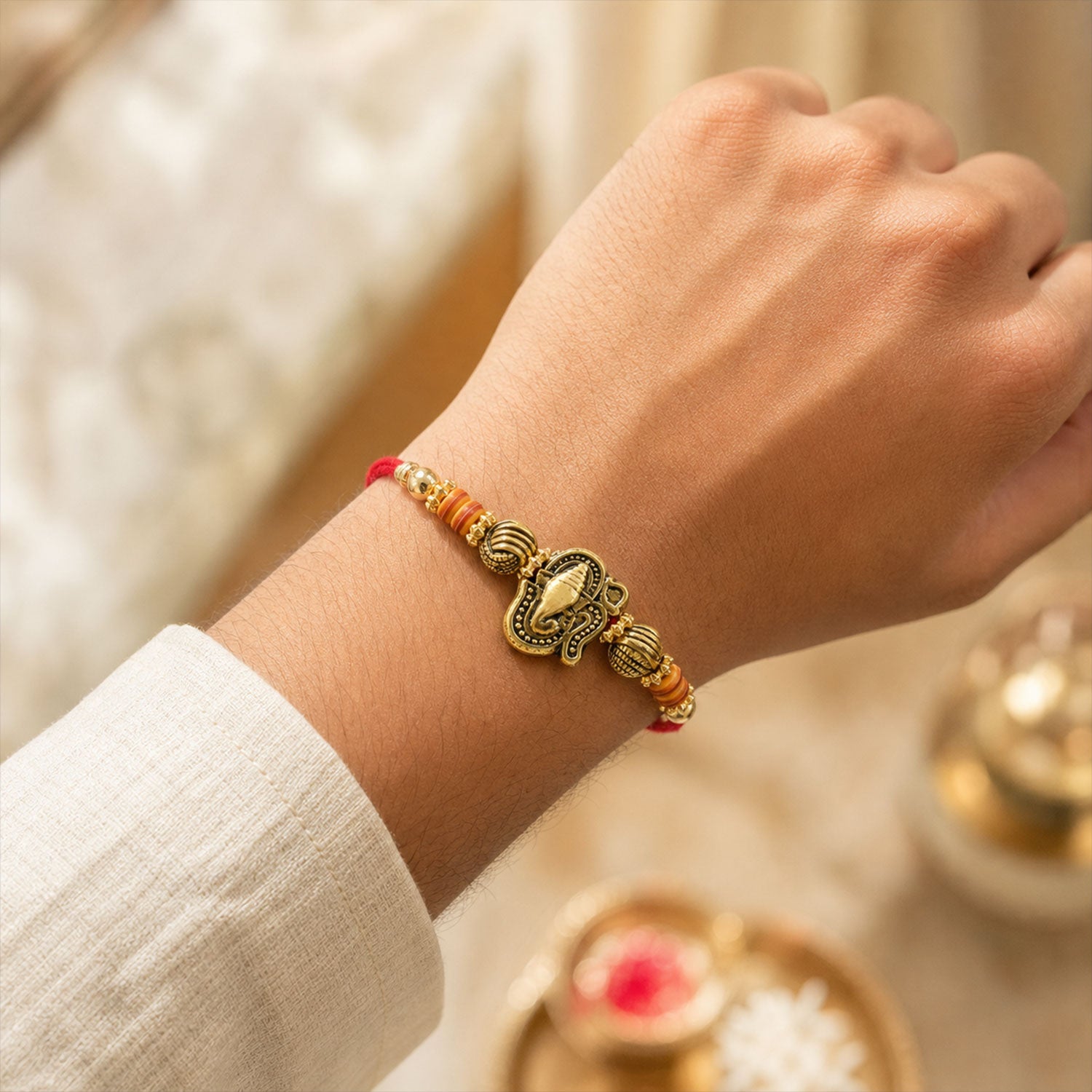 Red Thread Rakhi with Antique Gold Ganesha Pendant and Beaded Charms