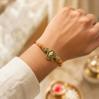 Red Thread Rakhi with Antique Gold Ganesha Pendant and Beaded Charms