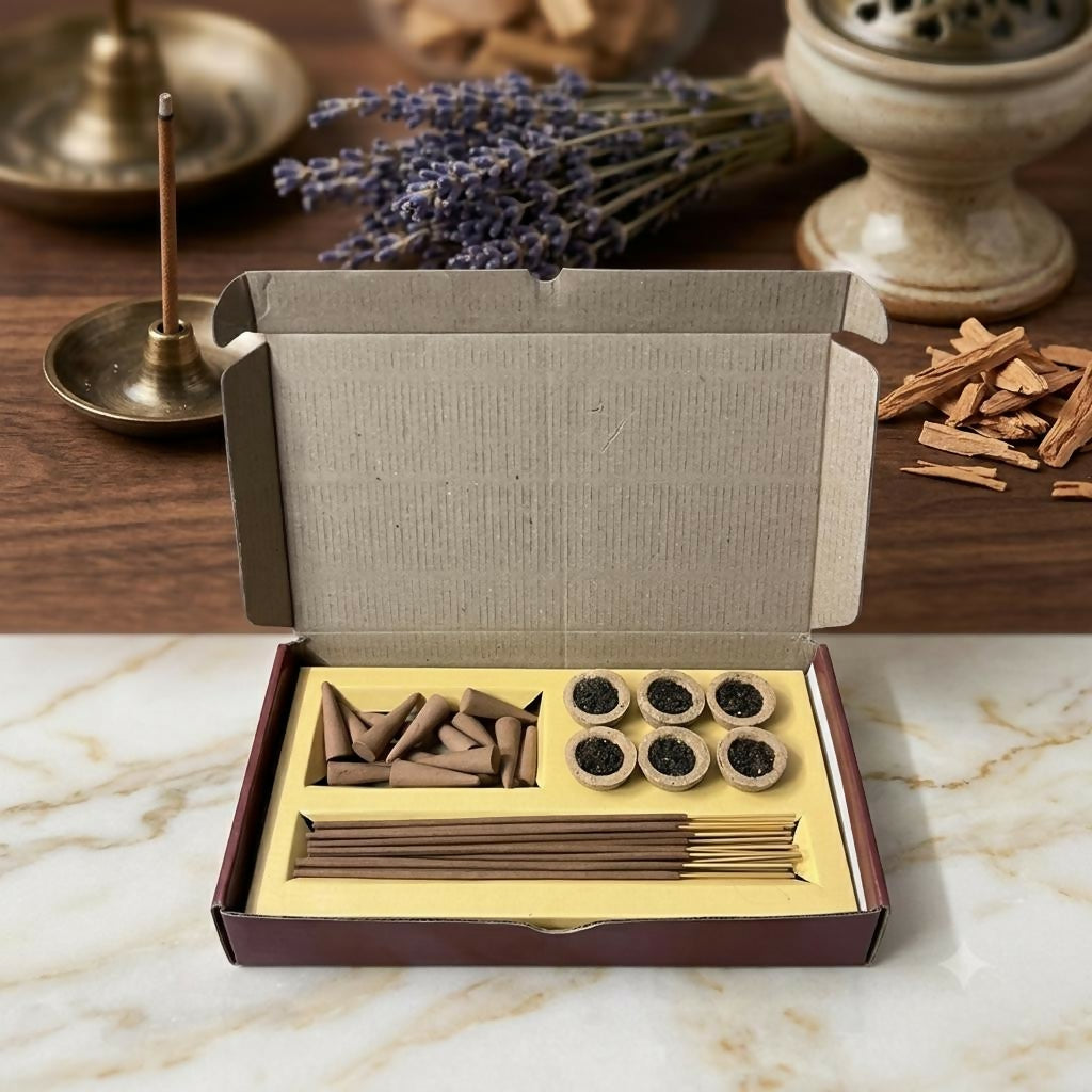 An open cardboard box containing incense cones, sambrani cups, and sticks on a marble surface with lavender in the