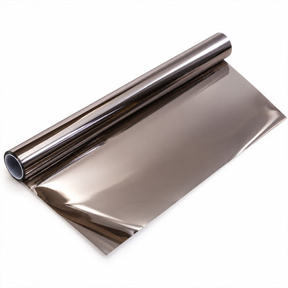 A roll of shiny, dark brown reflective window film partially unrolled on a plain white surface.