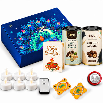 A blue peacock-patterned box, two chocolate tins, a Diwali card, six LED tealights, a remote, two yellow Shubh Labh decor,