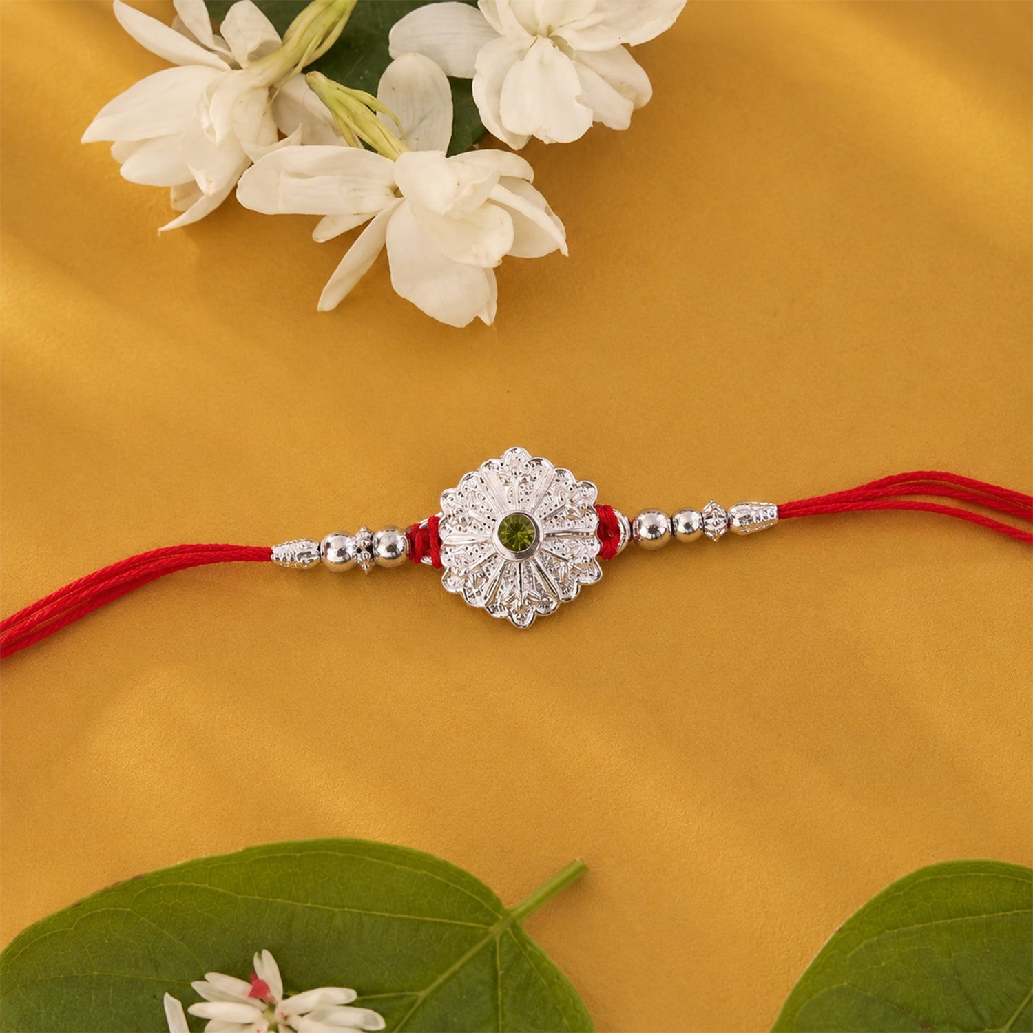 White Daisy Rakhi with Silver Beads and Soft Green Stone Center