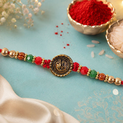 Ganesha Golden Medallion Devotional Rakhi with Red Green Beads and Festive Thread
