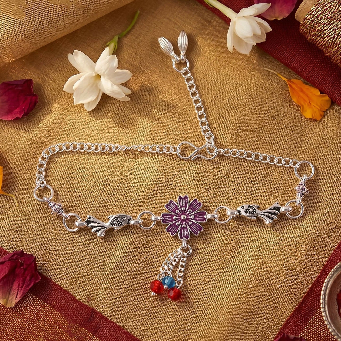 Close-up of silver flower charm bracelet with bird charms