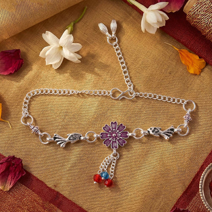 Close-up of silver flower charm bracelet with bird charms