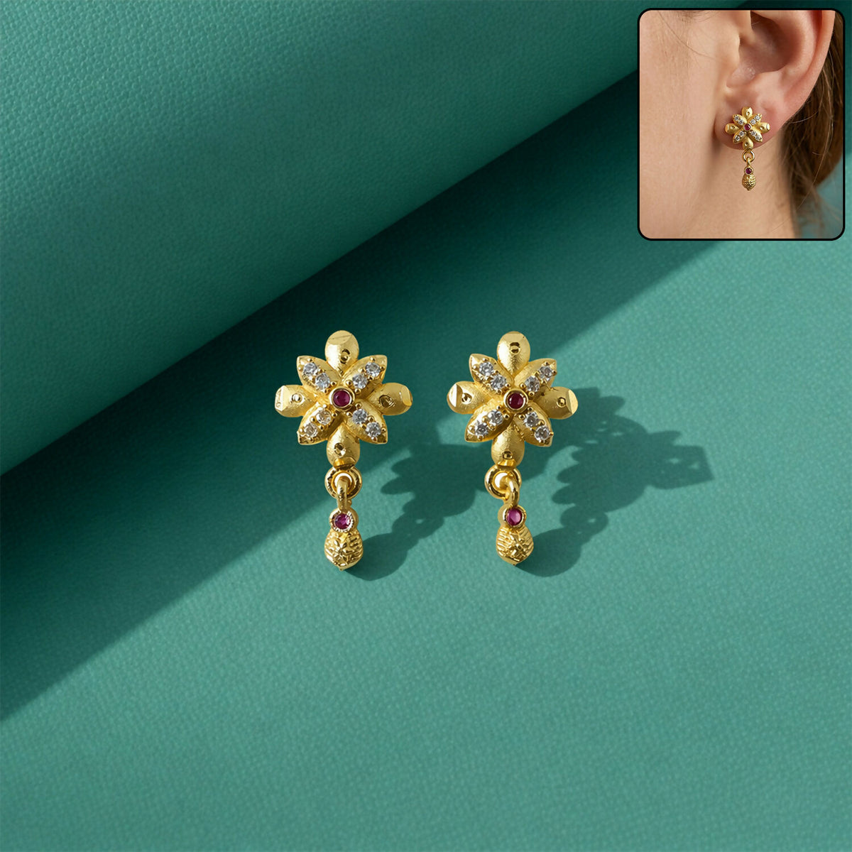 Elegant floral design gold plated drop earrings showcased on a model.