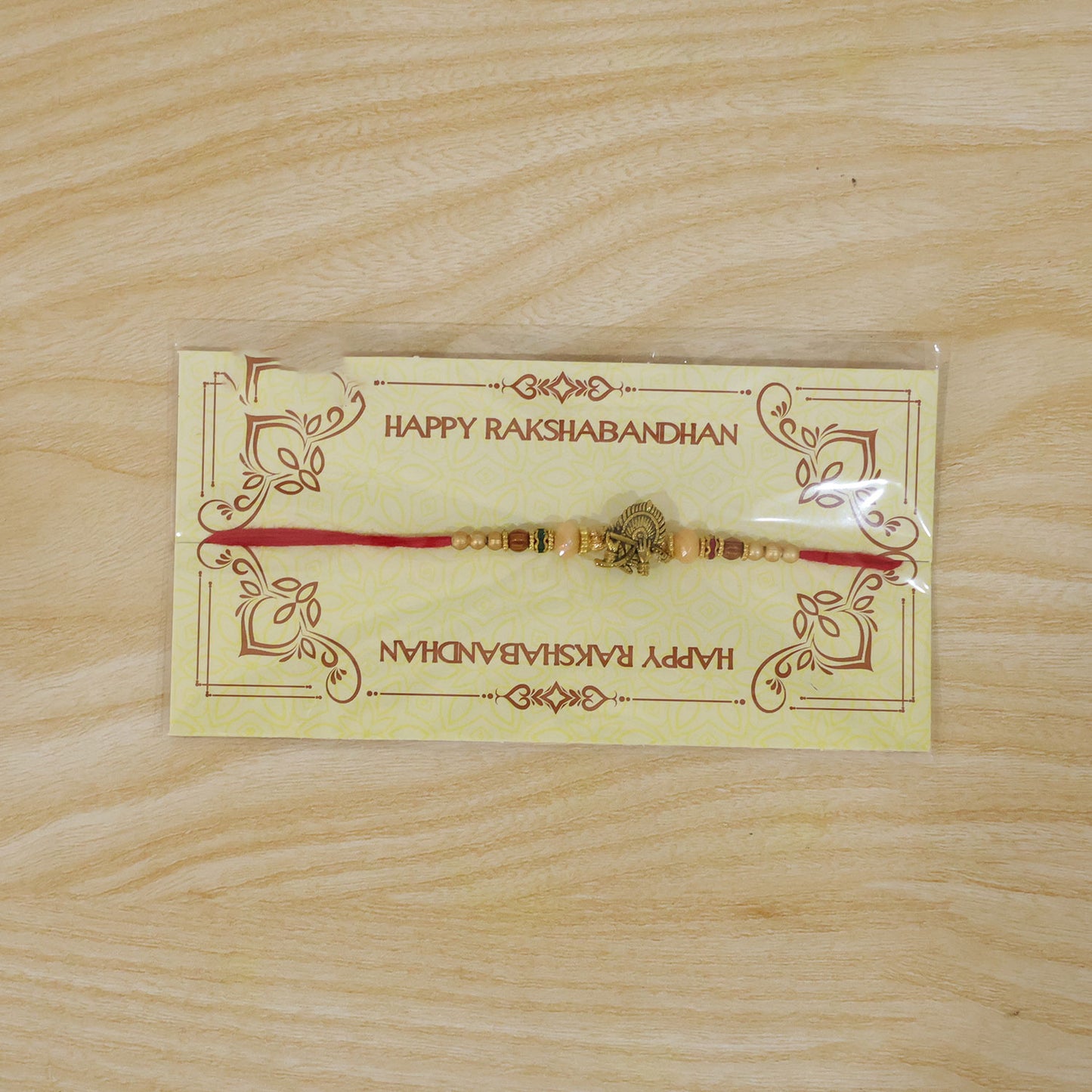Krishna Flute Peacock Devotional Rakhi with Antique Gold Centre and Peach Beads