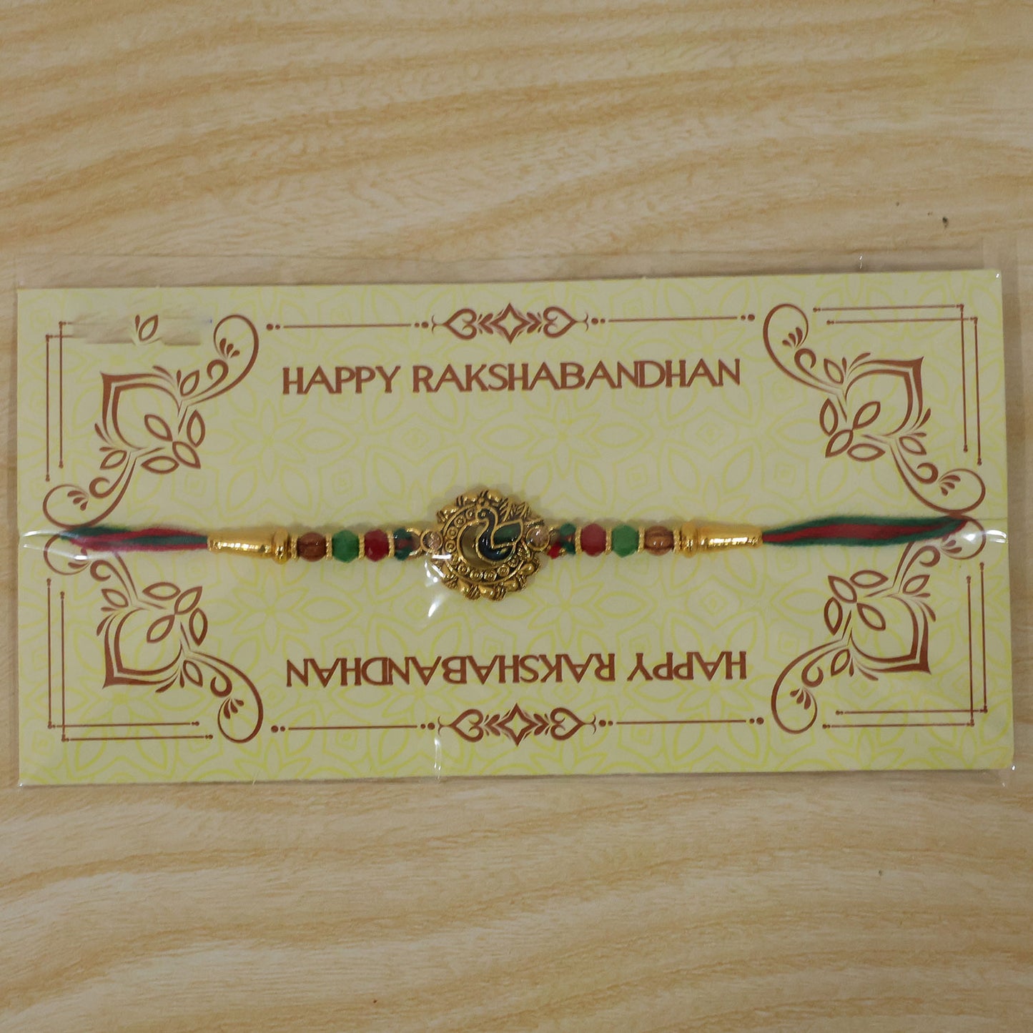 Green Peacock Enamel Rakhi with Golden Medallion, Multicolor Beads and Red Thread