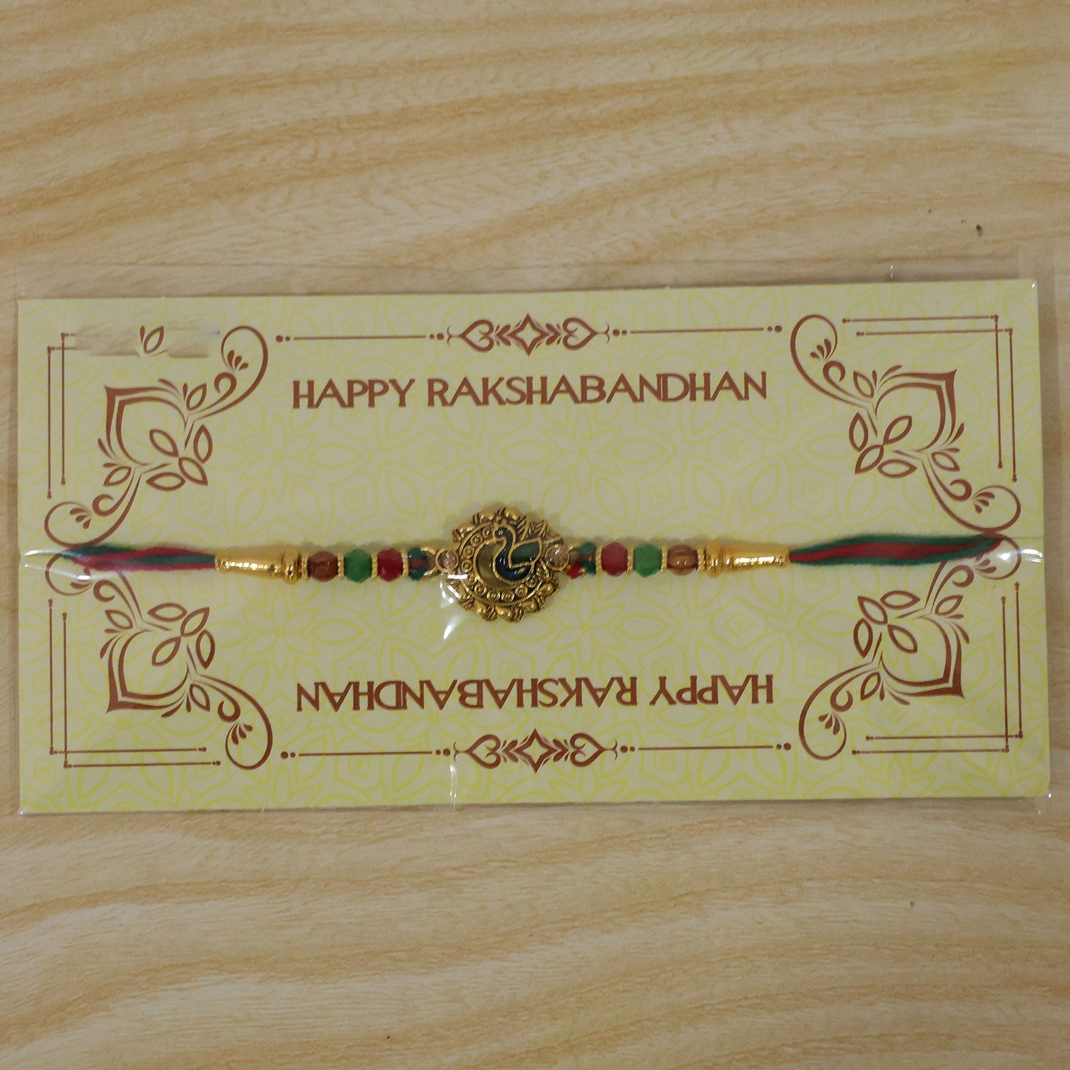 Green Peacock Enamel Rakhi with Golden Medallion, Multicolor Beads and Red Thread