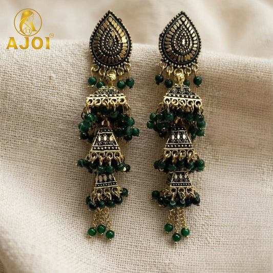 Front view of antique gold triple jhumka earrings with green beads