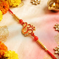 Auspicious Om & Ganesha Enamel Designer Rakhi for Brother Golden Stonework Motif with Red Beads & Thread