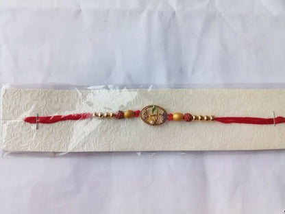 A red thread bracelet with a purple oval charm and beads is presented in clear packaging on a white textured card.