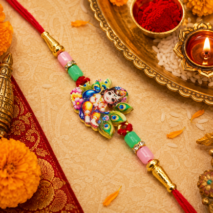 A colorful Rakhi with a Lord Krishna motif and peacock feathers is surrounded by traditional Hindu ceremonial items.