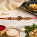 Red Thread Rakhi with Amber Beads and Antique Gold Oval Charm