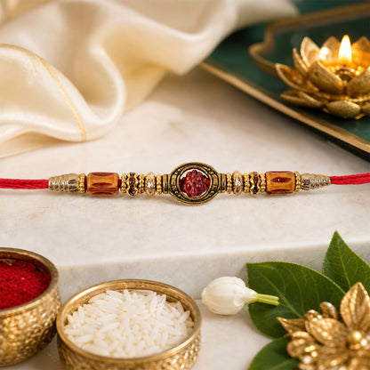 Red Thread Rakhi with Amber Beads and Antique Gold Oval Charm