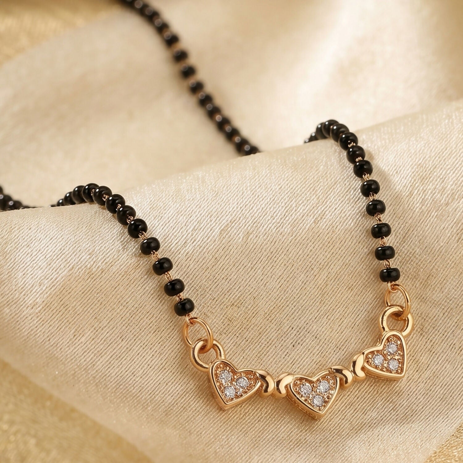 Close-up of traditional mangalsutra necklace with black bead chain and sparkling crystals.