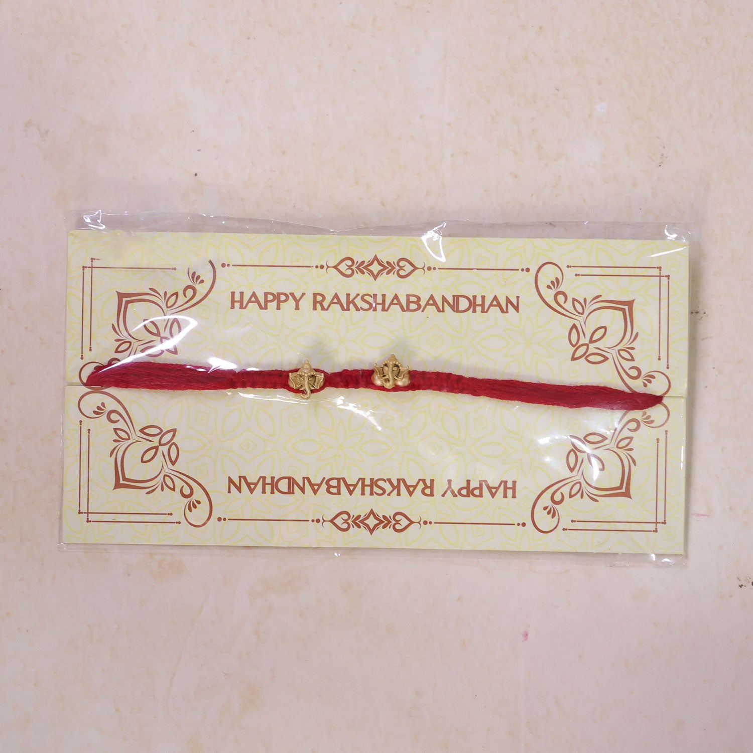 Red Thread Rakhi with Twin Antique Gold Ganesha Shaped Charms
