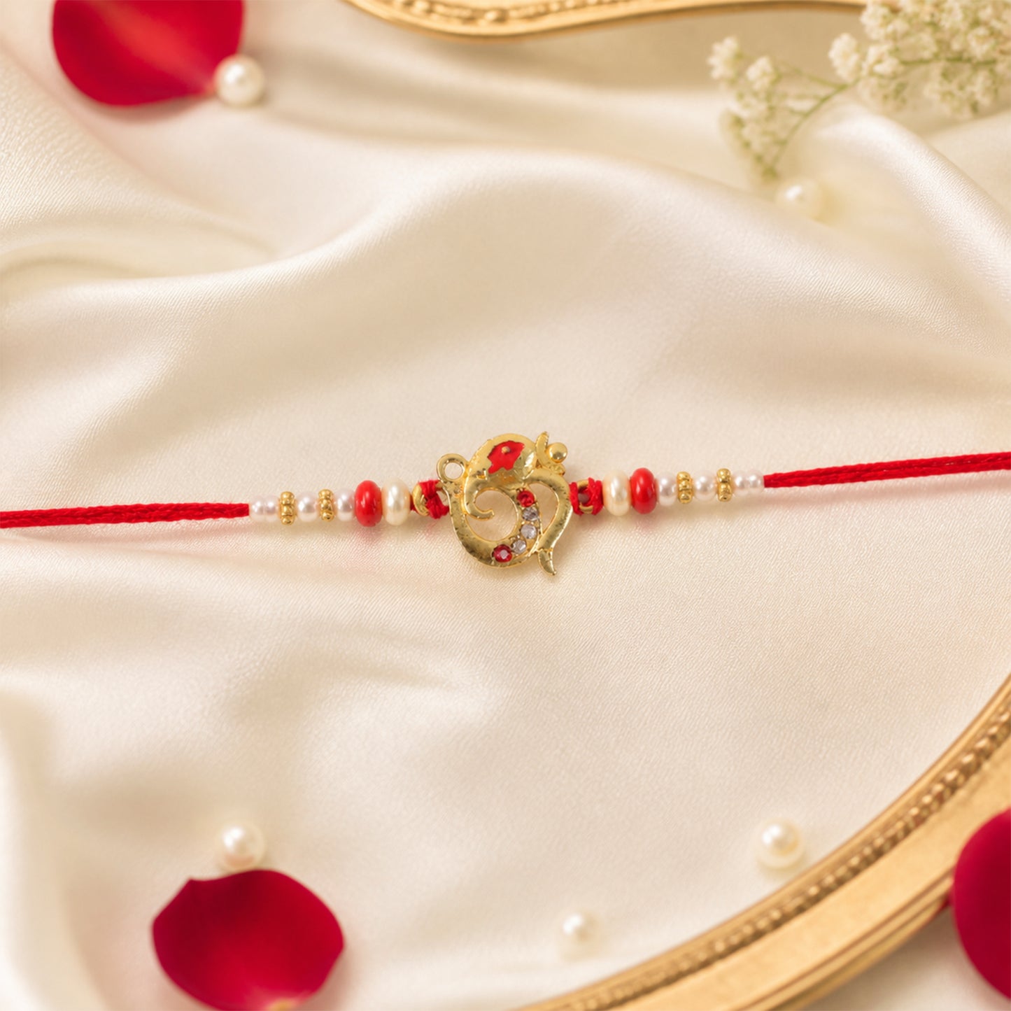 Golden Om Rakhi with Red Beads and Pearl Dotted Thread
