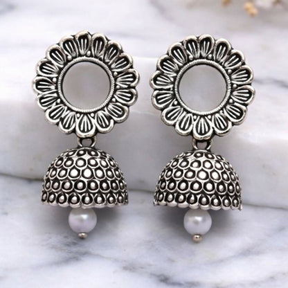 Side view of oxidized silver jhumka earrings displaying detailed floral pattern