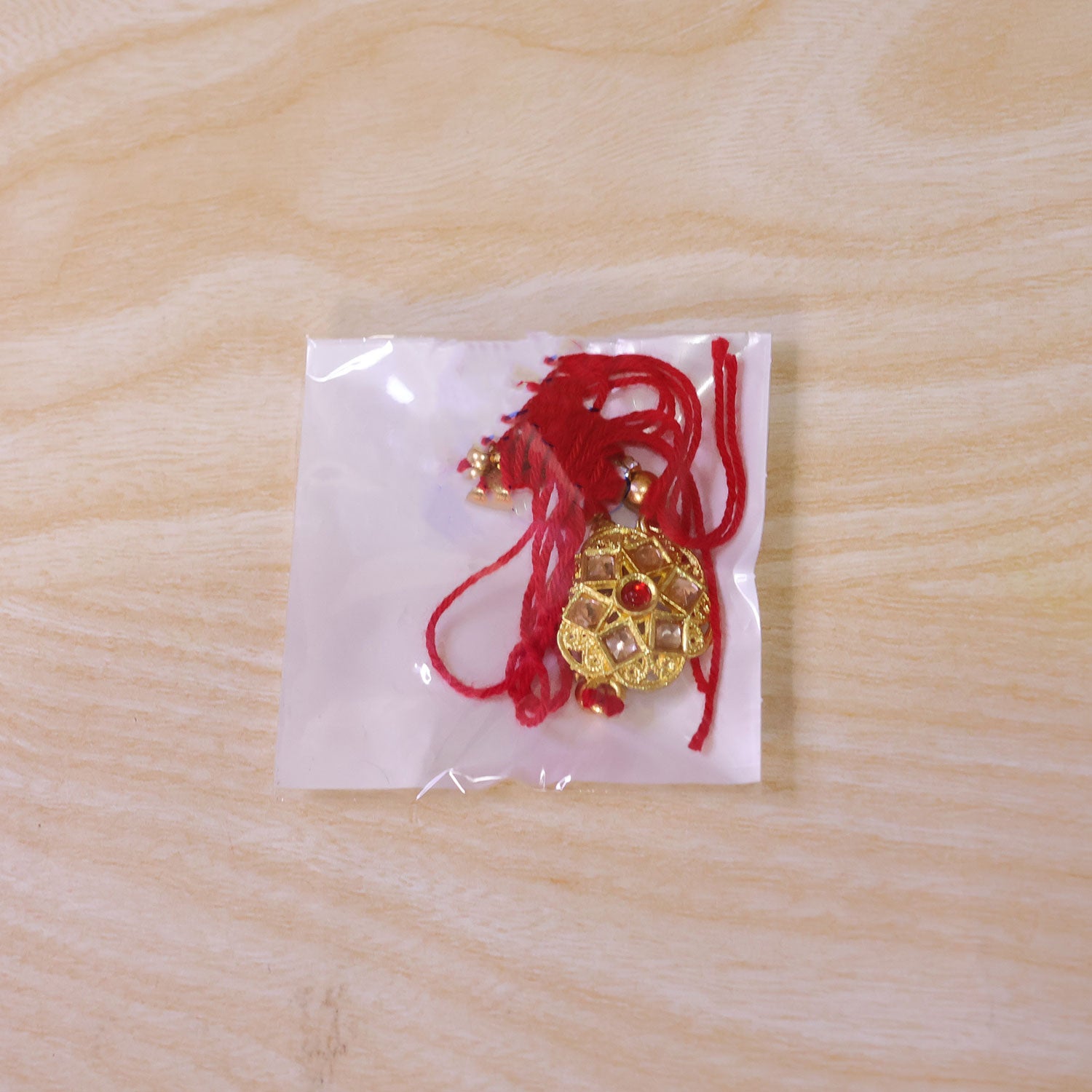Divine Rakhi with Circular Sacred Medallion and gold trims in chain look for Gift Use