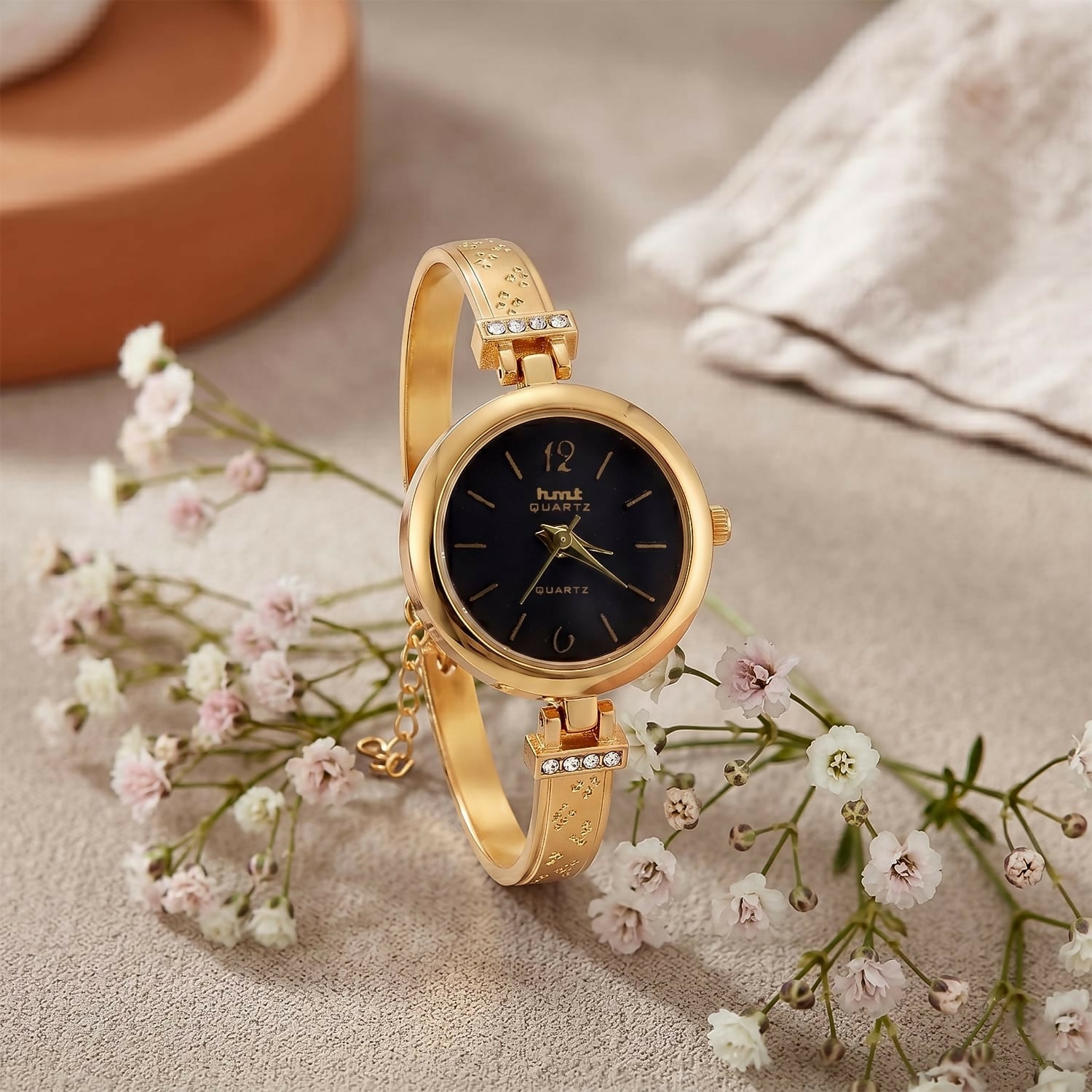 Golden bracelet-style watch side angle with decorative strap
