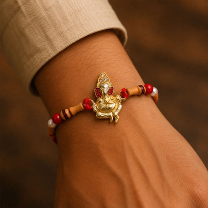 Gold Ganesh Charm Rakhi with Wooden Beads and Pearl Accents