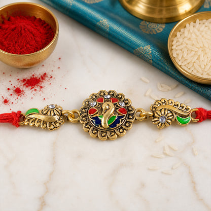Antique Gold-Toned Peacock Rakhi with Multicolor Enamel, Crystal Accents & Red Thread