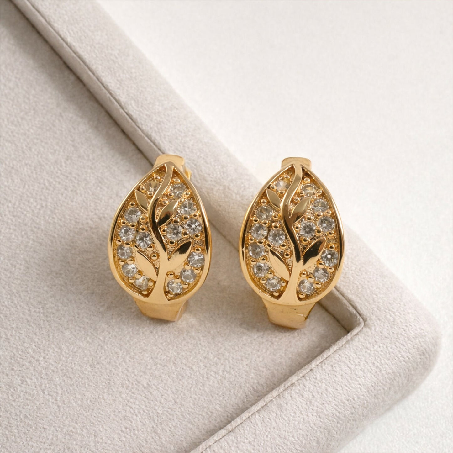 Stylish gold-tone leaf design stud earrings with shimmering stones