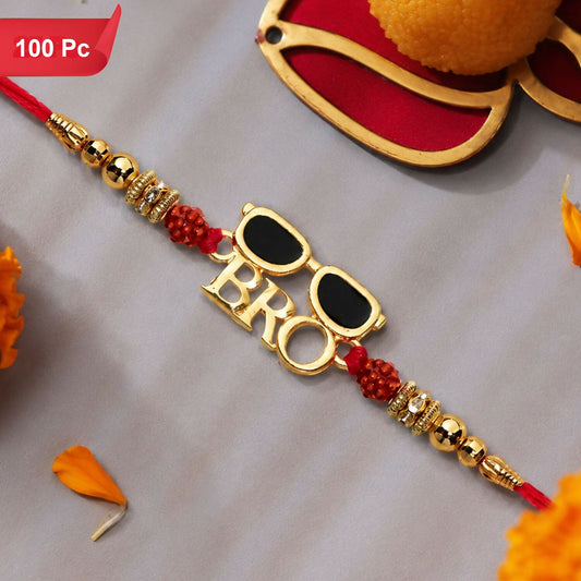 A red thread bracelet with gold beads and a gold charm spelling "BRO" with sunglasses, next to a sweet and flower petals.