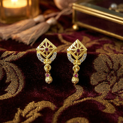 Close-up of handcrafted traditional gold earrings with detailed leaf design