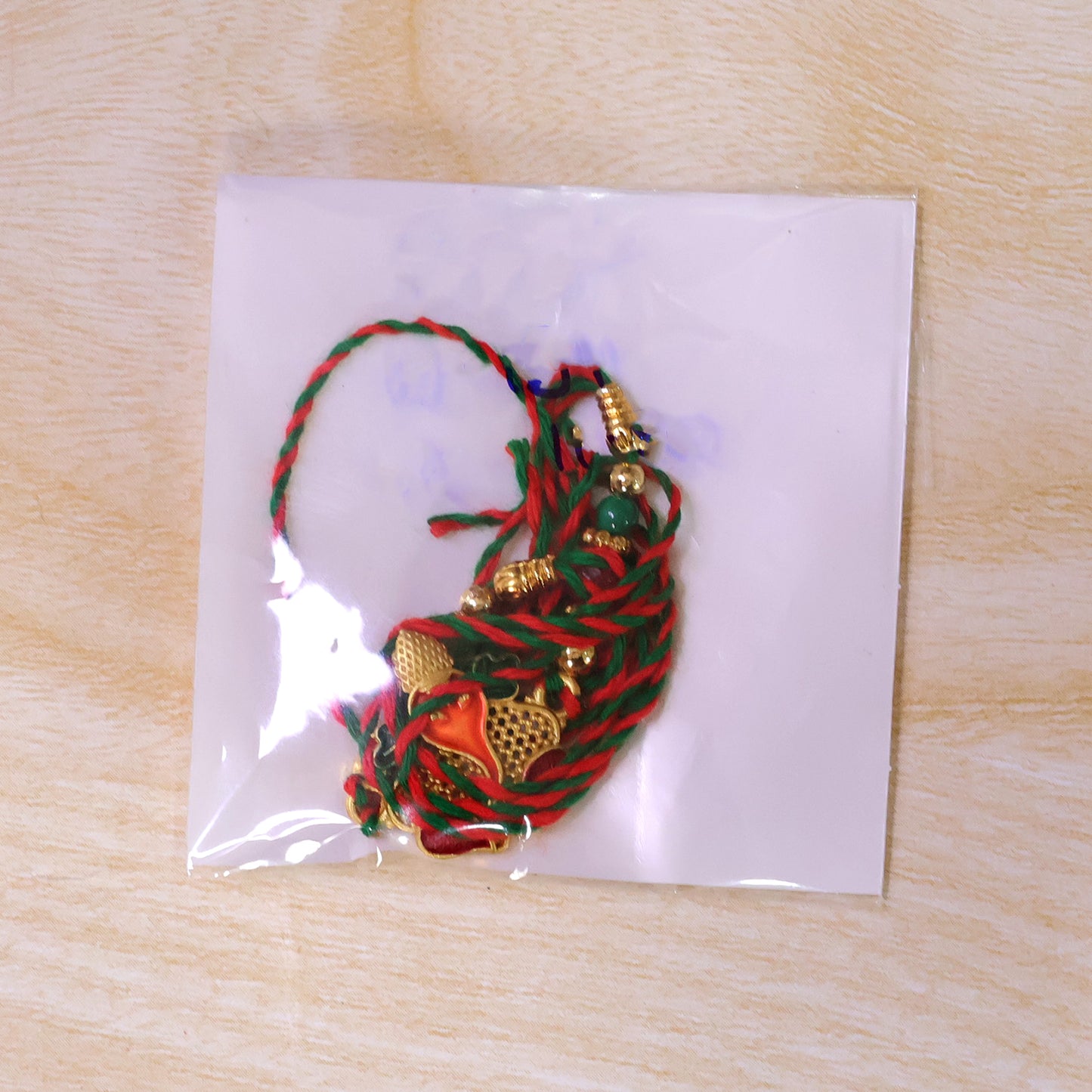 Gold Ganesha Pendant Rakhi with Red and Green Enamel