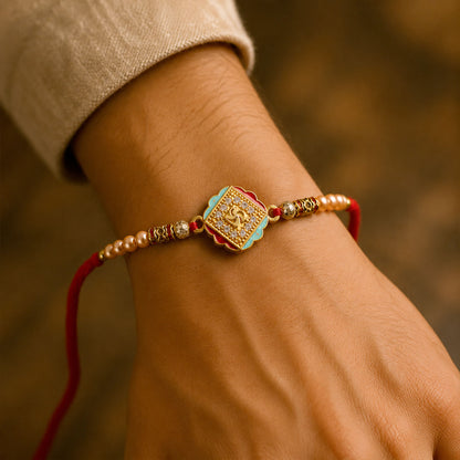 Silver Rakhi with Golden Square Om Centre, Roli Chawal Coin and Peacock Gift Packing
