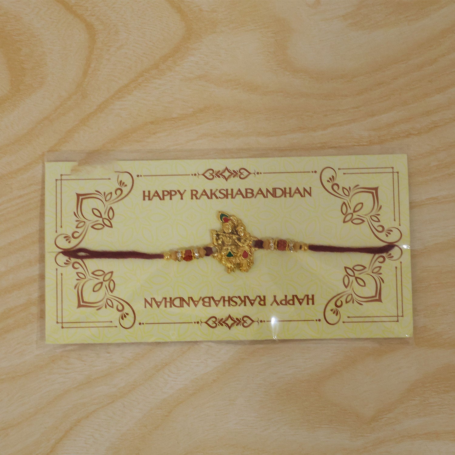 Radha Krishna Golden Devotional Rakhi with Couple Idol Centre and Color Stones