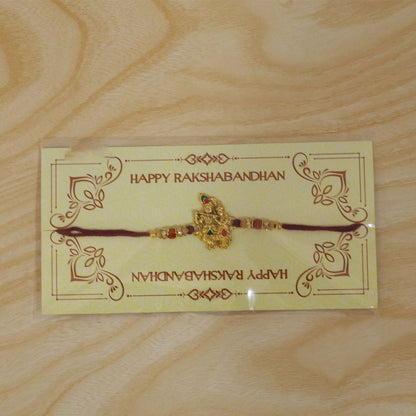 Radha Krishna Golden Devotional Rakhi with Couple Idol Centre and Color Stones