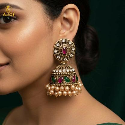 Close-up of Antique Gold Jhumka Earrings with Green & Pink Stone Work