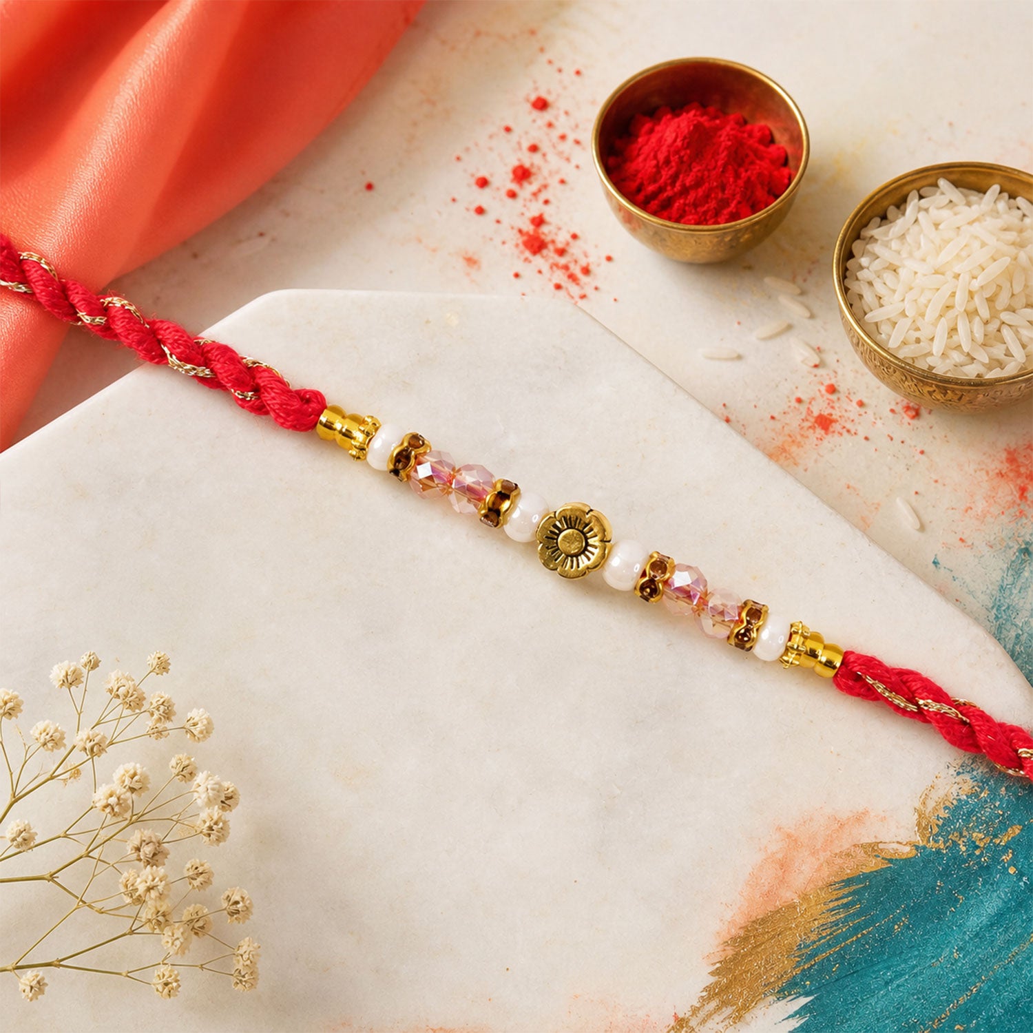 Red Thread Rakhi with Pearls, Crystal Beads and a Gold Flower Charm