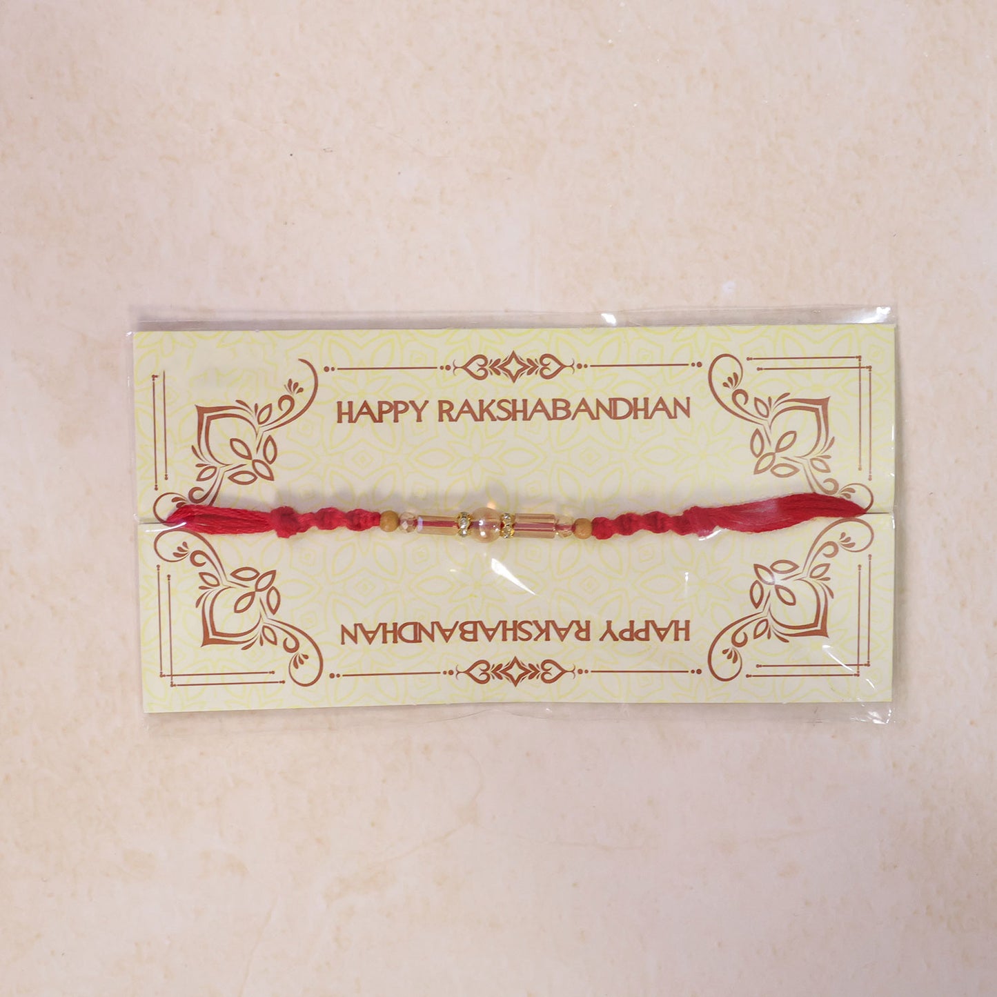 Red Braided Rakhi with Wooden Beads and a Pink Crystal Cylinder Bead