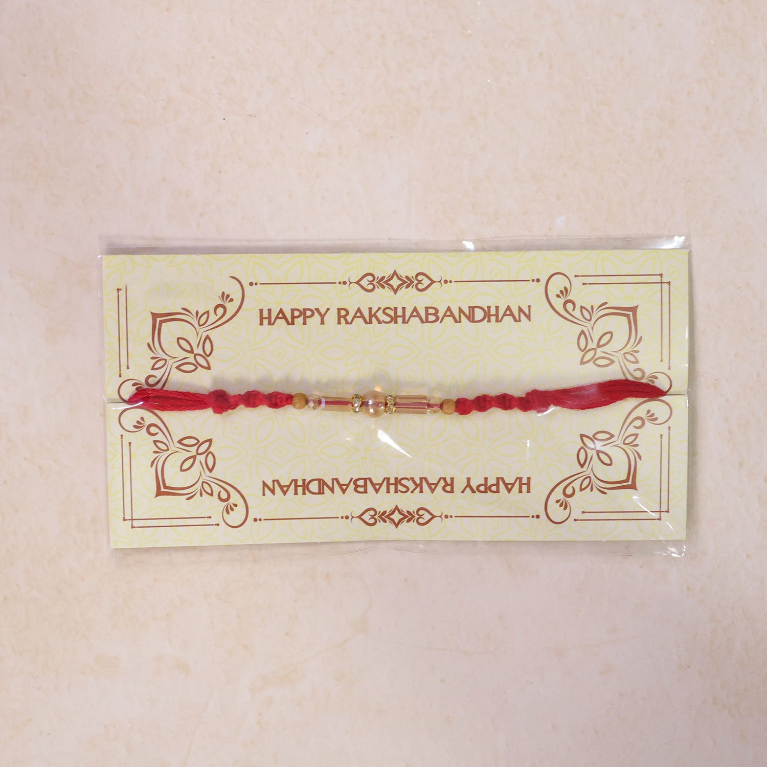 Red Braided Rakhi with Wooden Beads and a Pink Crystal Cylinder Bead