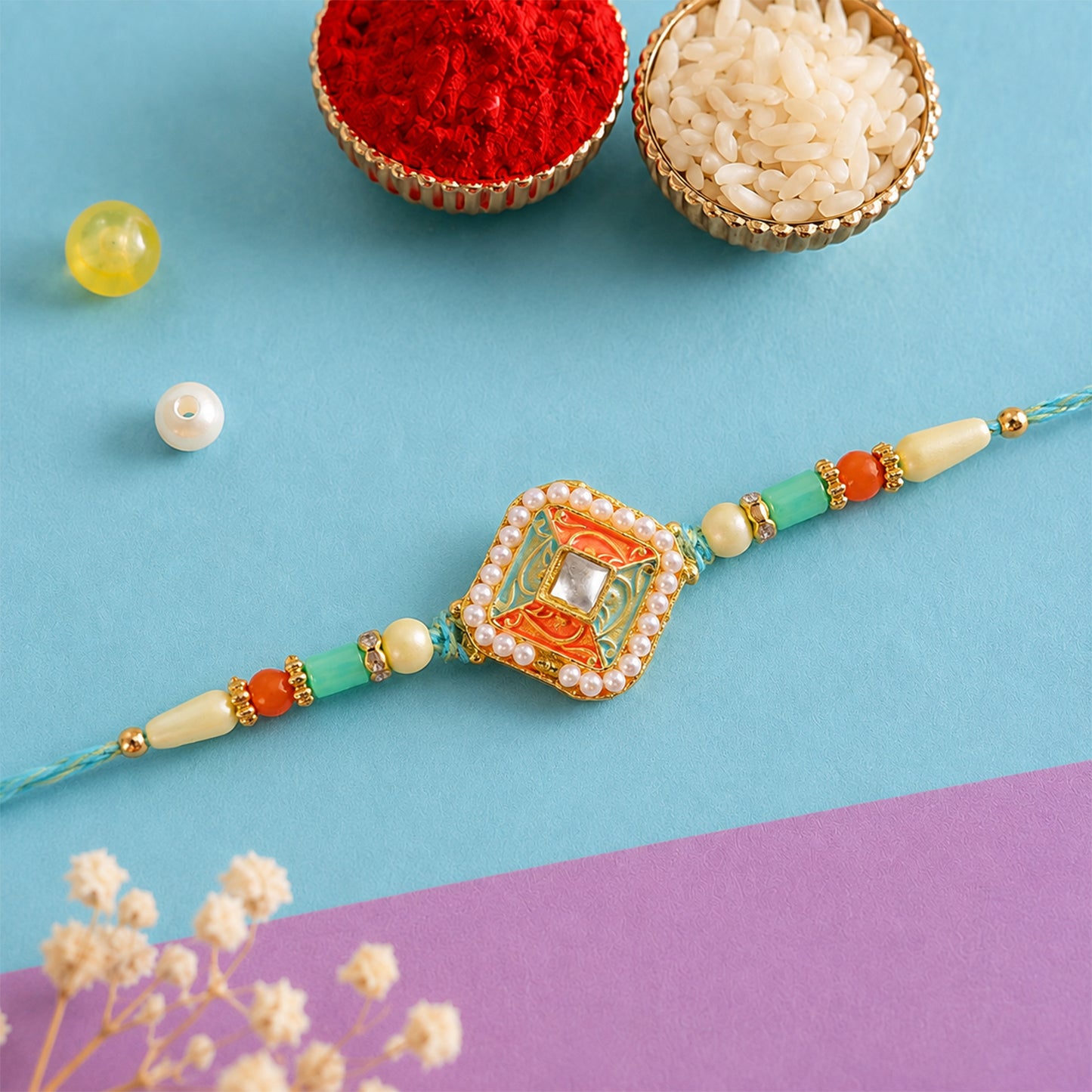 Pearl Bordered Meenakari Pendant Rakhi with Orange and Teal Enamel