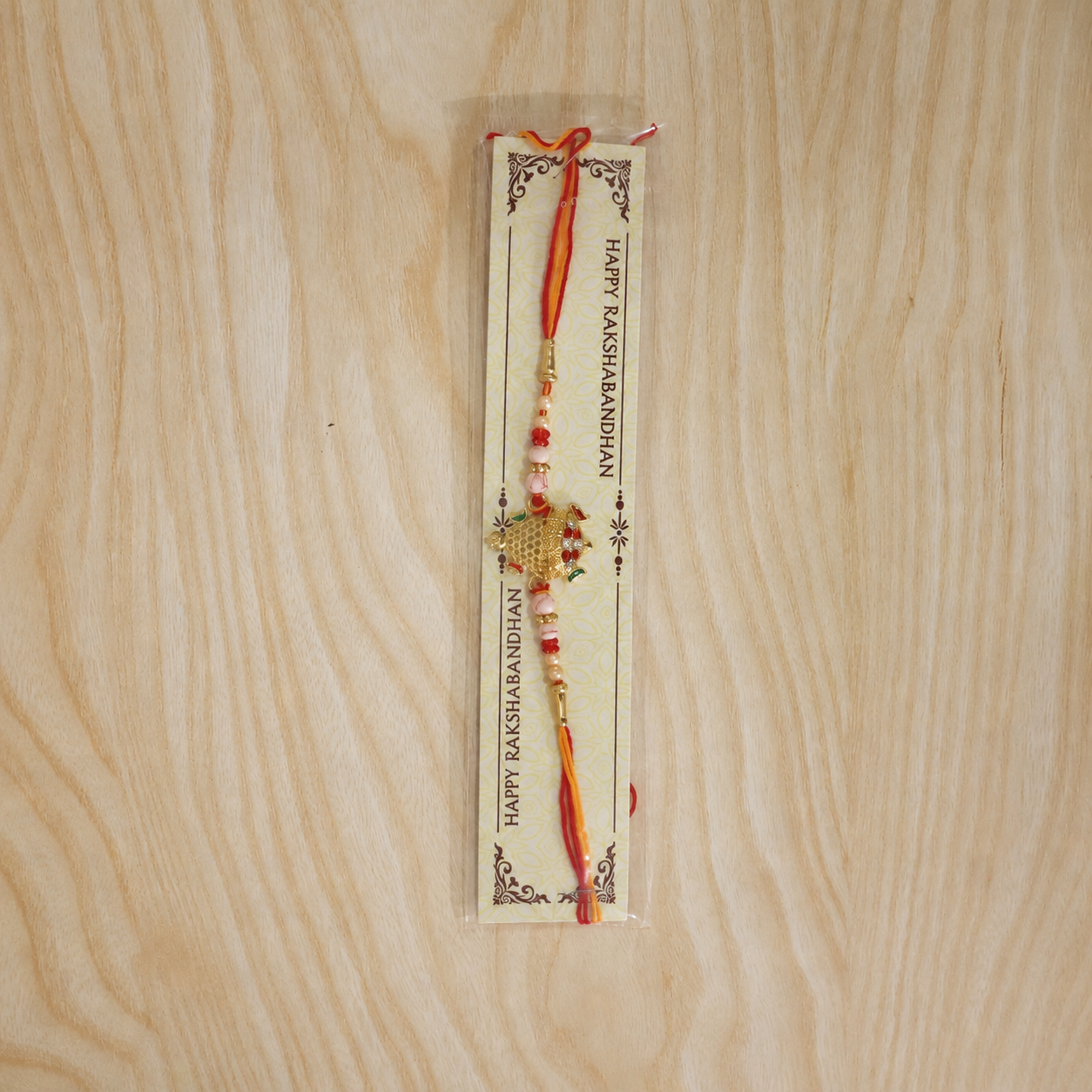 Gold Turtle Rakhi with Pink Pearls and Red Thread